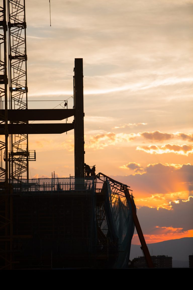 Silhouette of the construction site on sunset background